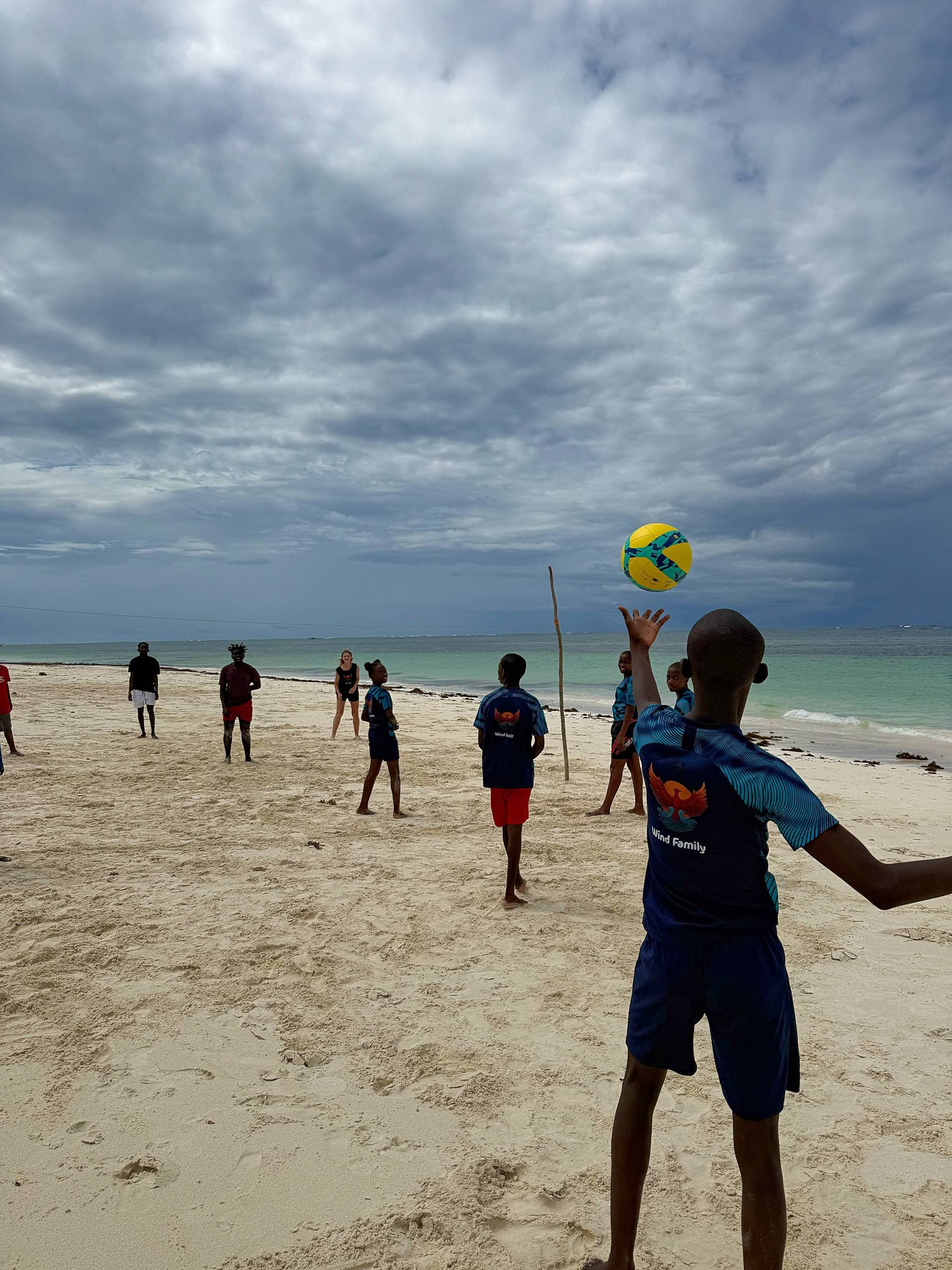 Scholarship kids playing beach volleyball on a windless afternoon at Watamu